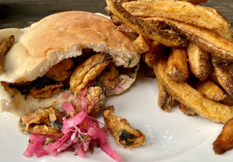 Chef Shay Lavi’s fried mussel sandwich (shown with fries) is a tribute to a dish he enjoyed on summer visits to the Turkish seaside as a youngster. Wendell Brock for The Atlanta Journal-Constitution