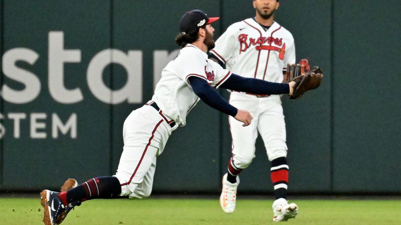 Atlanta Braves shortstop Dansby Swanson (7) makes an over the shoulder catch of the pop up by Philadelphia Phillies’ J.T. Realmuto during the sixth inning of Game 2 of the National League Division Series at Truist Park in Atlanta on Wednesday, Oct. 12, 2022. (Hyosub Shin / Hyosub.Shin@ajc.com)