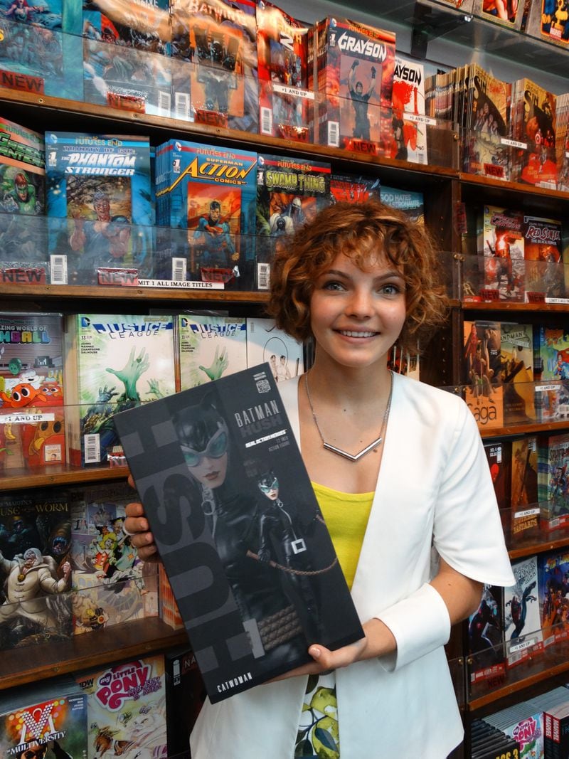 Camren holds a Catwoman in her arms at Oxford Comics & Books Sept. 3, 2014. CREDIT: Rodney Ho/rho@ajc.com