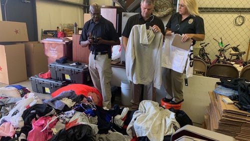 Covington police sort through piles of clothing reported stolen from Macy's department stores along the East Coast. The merchandise spilled onto I-20 last Friday after a police chase and wreck, authorities said.