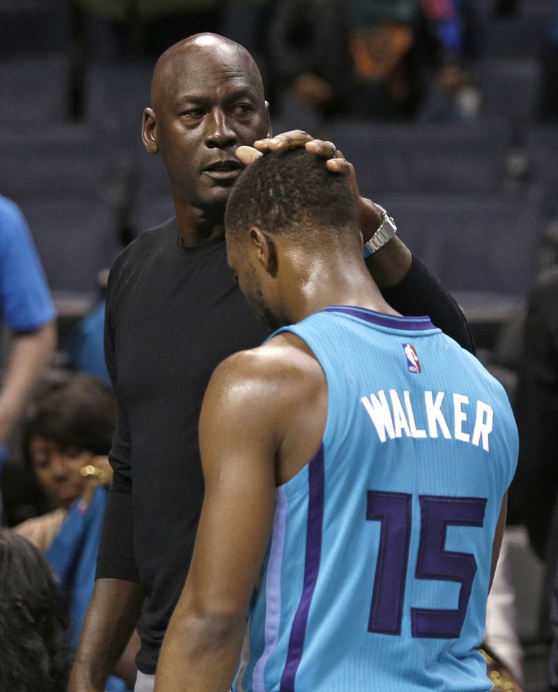 Charlotte Hornets owner Michael Jordan, left, pats Kemba Walker, right, on the head after a home loss to the Atlanta Hawks in 2015. The Hawks won 94-92. (AP Photo/Chuck Burton)