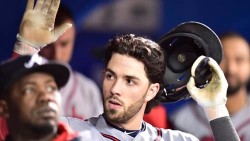 Dansby Swanson is congratulated in the dugout after putting the Braves ahead with a seventh-inning home run Tuesday at Toronto. (Frank Gunn/The Canadian Press via AP)