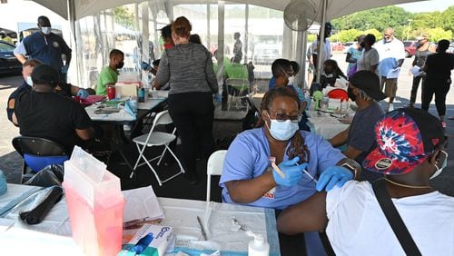 Hattie Ross, a registered nurse with the DeKalb County Board of Health (foreground), administers the COVID-19 vaccine during an event at The Gallery at South DeKalb in Decatur on Saturday, August 13, 2021. More than 1,100 people were vaccinated. (Hyosub Shin / Hyosub.Shin@ajc.com)