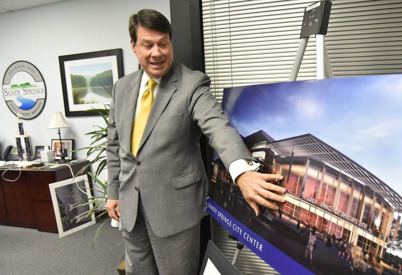Sandy Springs Mayor Rusty Paul, during an interview in December 2018, said his city’s opposition to a rehab group’s use of a Sandy Springs condo complex is a zoning battle, not a case of ostracizing the unwanted. The mayor is shown here at his office in May 2017, displaying concept photographs for Sandy Springs City Center. 
