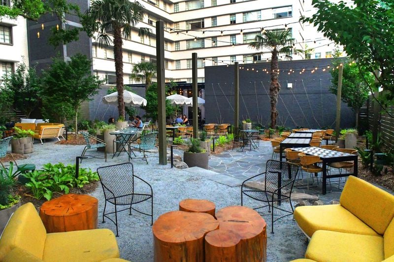 The open-air Willow Bar at the Kimpton Sylvan Hotel features a winding gravel path through soft seating choices underneath a canopy of old oak and palm trees. Chris Hunt for The Atlanta Journal-Constitution 