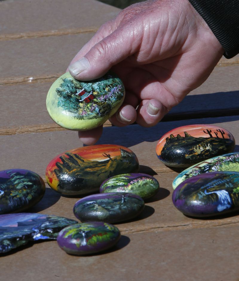 Don Thorn shows some of the rocks he has painted before placing them around Springfield Lake on April 20, 2018, in Springfield Township, Ohio. (Karen Schiely/Akron Beacon Journal/TNS)