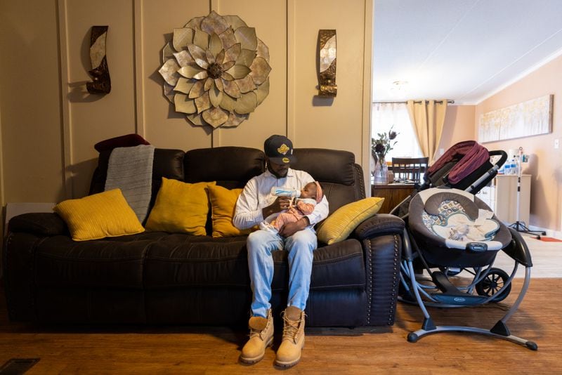 Raekwon Jenkins feeds his 7-month-old daughter Jayla, who was born prematurely, at their home in Toccoa on Thursday, November 10, 2022. (Arvin Temkar / arvin.temkar@ajc.com)