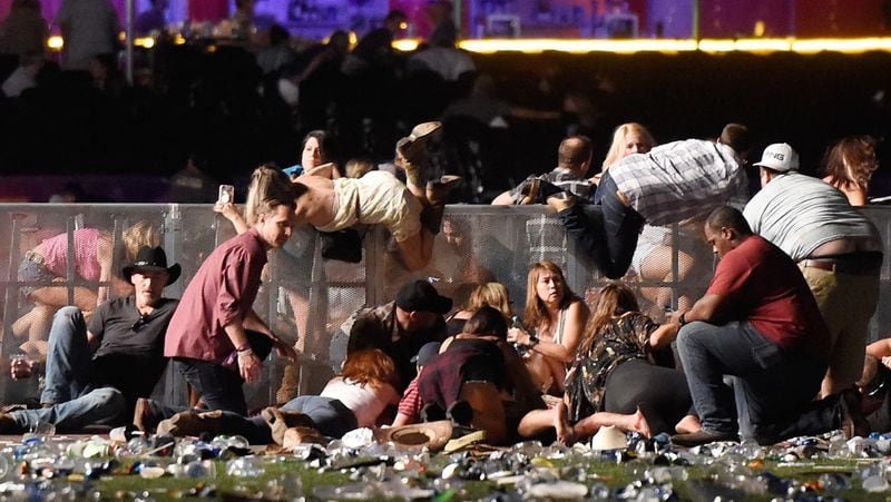 LAS VEGAS, NV - OCTOBER 01:  People scramble for shelter at the Route 91 Harvest country music festival after apparent gun fire was heard on October 1, 2017 in Las Vegas, Nevada. A gunman has opened fire on a music festival in Las Vegas, leaving at least 20 people dead and more than 100 injured. Police have confirmed that one suspect has been shot. The investigation is ongoing. (Photo by David Becker/Getty Images)