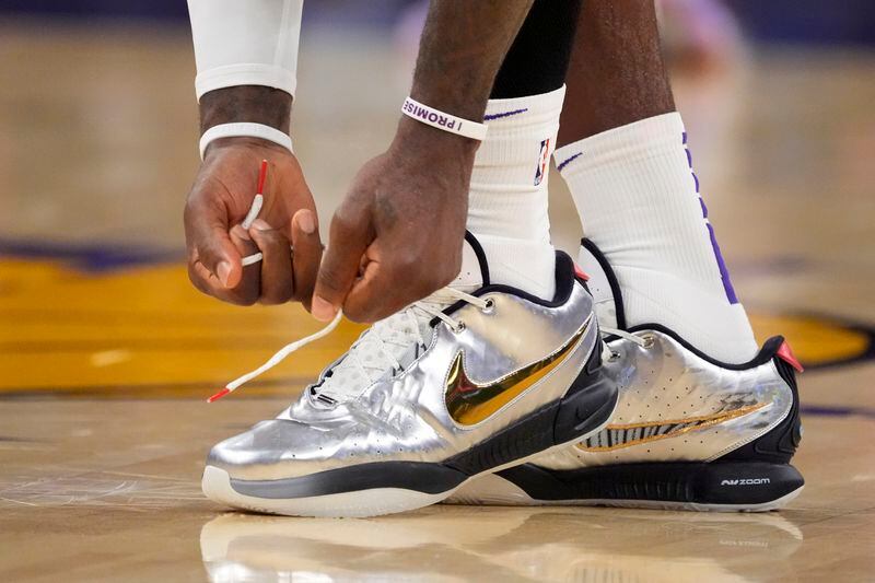 Los Angeles Lakers forward LeBron James ties his shoes during the first half in Game 4 of an NBA basketball first-round playoff series against the Denver Nuggets Saturday, April 27, 2024, in Los Angeles. (AP Photo/Mark J. Terrill)