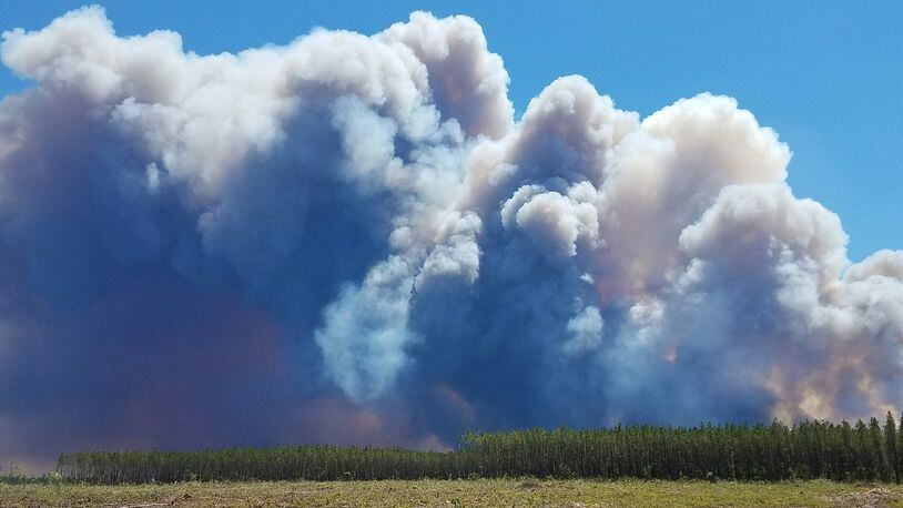 In this Saturday, May 6, 2017 photo provided by the Okefenokee National Wildlife Refuge smoke rises from a wildfire east of Fargo, Ga. Firefighters were battling Sunday to prevent the fire from spreading, authorities said. (Ben Palm/Okefenokee National Wildlife Refuge via AP)