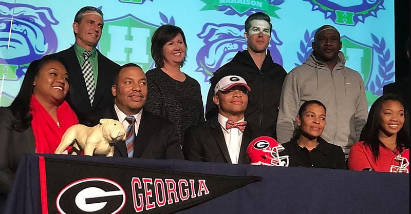 Quarterback Justin Fields (center) signed his letter of intent with Georgia Wednesday at Harrison High School.