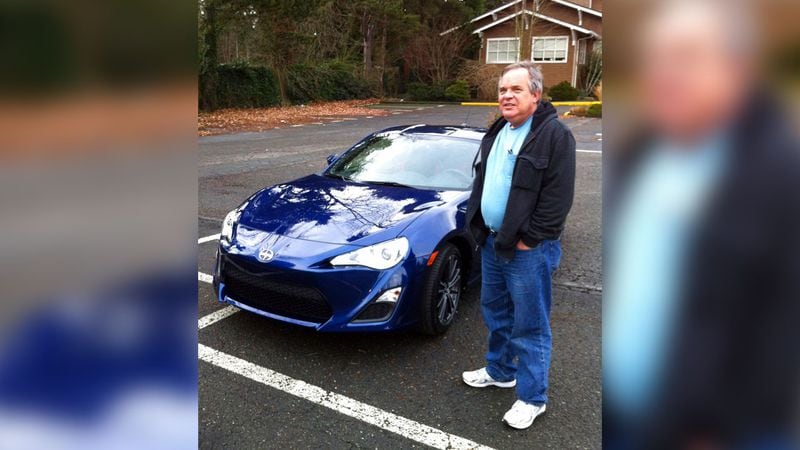 In this Dec. 14, 2013, photo provided by Shashi Karan, Alan Naiman poses with his new car, an unusual extravagance for him, in Seattle. When Naiman, a Washington state social worker, died this year of cancer at the age of 63, the generous loner left most of his surprise estate worth $11 million to children's charities helping the poor, sick, disabled, abandoned and those otherwise stuck in foster care, unbeknownst to those beneficiaries or his own loved ones.