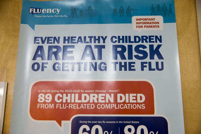 An Influenza Vaccine poster is displayed at Conyers Pediatrics in Conyers. (Alyssa Pointer/Atlanta Journal Constitution)
