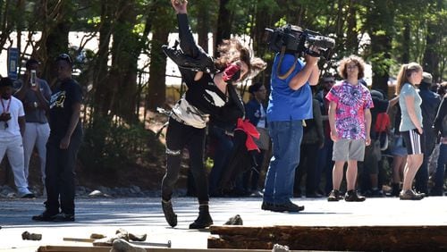 April 23, 2016 Stone Mountain - A counter-protester throws a rock at police during a clash at Stone Mountain Park on Saturday, April 23, 2016. Violent protests surrounding a white power rally at Stone Mountain have caused officials to shut down public attractions at the park. HYOSUB SHIN / HSHIN@AJC.COM