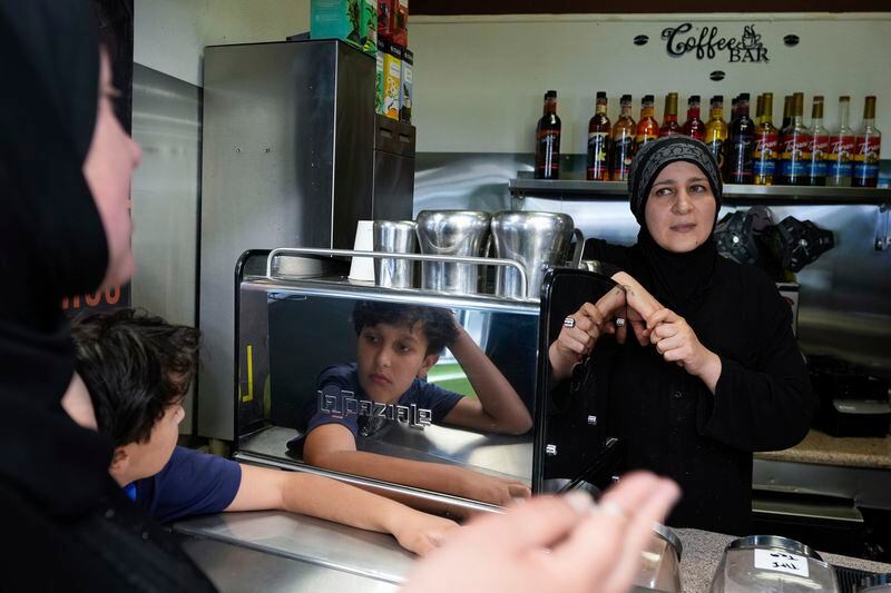 Tatiana Alabsi, left to right, and her son Sami visit with Iman Diab, who owns a cafe, in the Tenderloin neighborhood Saturday, April 20, 2024, in San Francisco. (AP Photo/Godofredo A. Vásquez)