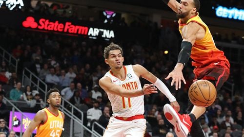 The Hawks Trae Young wraps a pass around formidable Utah center Rudy Gobert last month.
