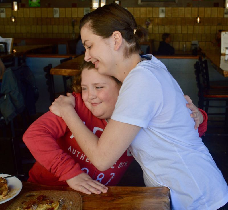 Chef Savannah Sasser (right) shares a hug with aspiring chef Olivia Speaks. (photo: HENRI HOLLIS)
