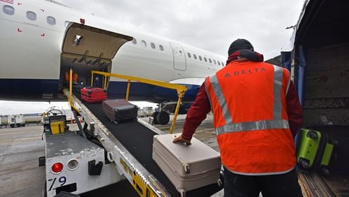 Delta baggage crew Danny Carpenter loads bags at Hartsfield-Jackson International Airport on Wednesday, February 27, 2019.  HYOSUB SHIN / HSHIN@AJC.COM