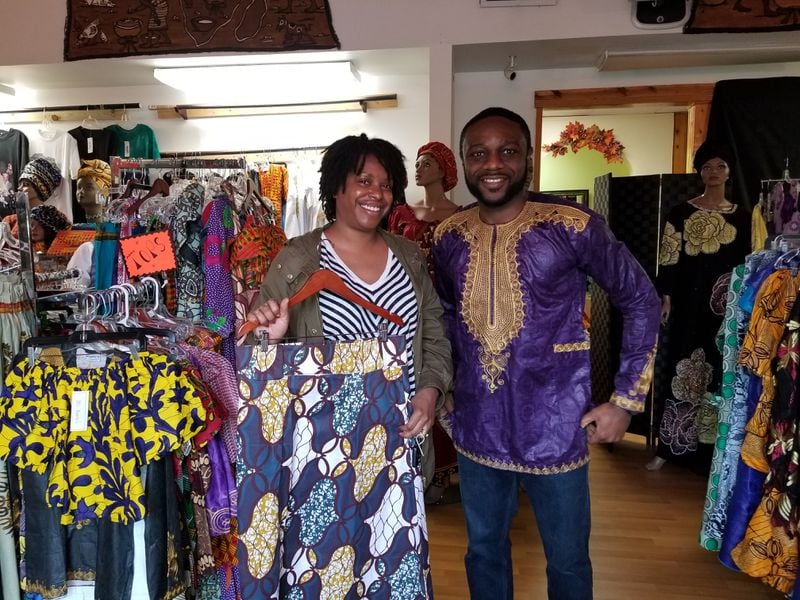 James Onabanjo, co-owner of Dupsie's African Clothing in Smyrna poses with customer Nikki Igbo who stopped in to purchase clothing for the "Black Panther," which opens this weekend.