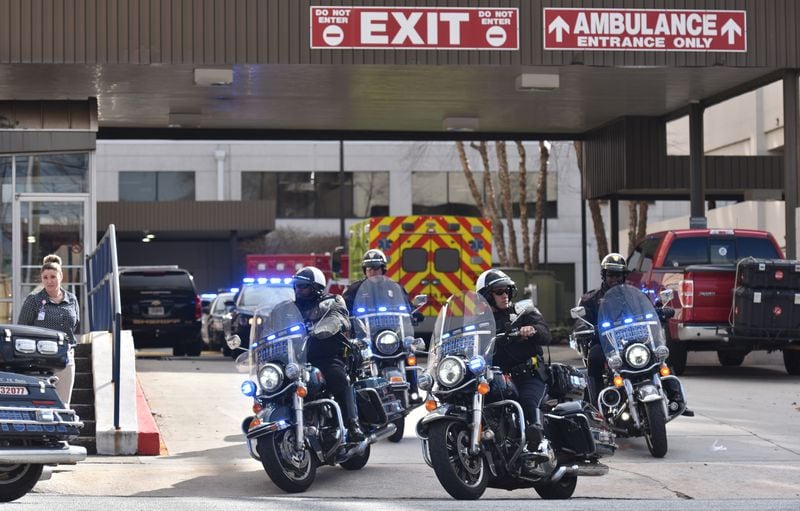 February 9, 2018 Atlanta - Henry County ambulance leaves escorted by a police motorcycle at Atlanta Medical Center, where two wounded Henry County sheriff's deputies were treated, on Friday, February 9, 2018. A Locust Grove police officer was killed and two Henry County sheriff's deputies were wounded when they tried to serve an arrest warrant Friday at a home on St. Francis Court, authorities said. HYOSUB SHIN / HSHIN@AJC.COM