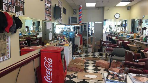A burglar broke through the wall and ceiling of a Roswell barbershop Thursday to try to get away from SWAT officers, police said.