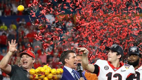 12/31/21 - Miami Gardens -  Georgia head coach Kirby Smart and quarterback Stetson Bennett toss oranges from the trophy stage after beating Michigan 34-11 to win the Orange Bowl at Hard Rock Stadium on Friday, Dec 31, 2021, in Miami Gardens.   Curtis Compton / Curtis.Compton@ajc.com 