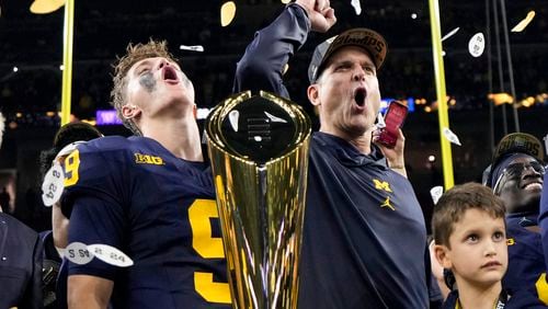 Michigan head coach Jim Harbaugh and quarterback J.J. McCarthy celebrate with the trophy after their win against Washington in the national championship NCAA College Football Playoff game Monday, Jan. 8, 2024, in Houston. (AP Photo/David J. Phillip)