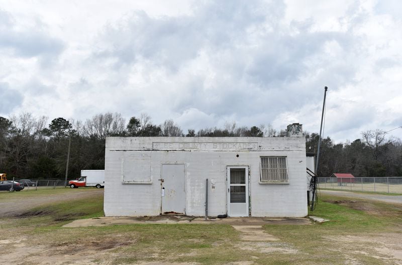 The Lee County Stockade is a decrepit white concrete building that now sits in the shadow of a school bus depot. 