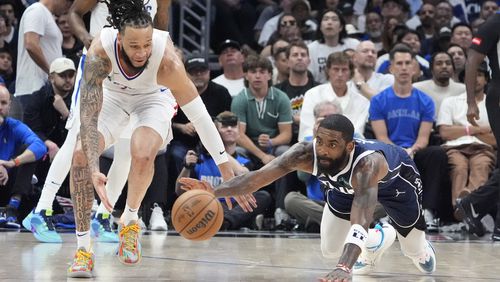 Los Angeles Clippers guard Amir Coffey, left, and Dallas Mavericks guard Kyrie Irving go after a loose ball during the second half in Game 5 of an NBA basketball first-round playoff series Wednesday, May 1, 2024, in Los Angeles. (AP Photo/Mark J. Terrill)
