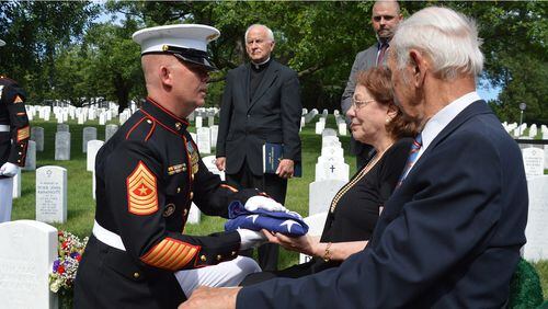 Jane Pawelski receives the flag used during the memorial ceremony for her brother, Marine Sgt. John Baczewski, at Arlington National Cemetery. Sgt. Baczewski was remembered with full military honors 63 years after he was killed in Korea at the age of 21.