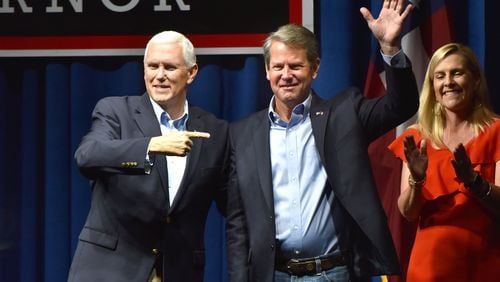 Vice President Mike Pence, left, and GOP gubernatorial candidate Brian Kemp wave to supporters Thursday at the Dalton Convention Center. HYOSUB SHIN / HSHIN@AJC.COM