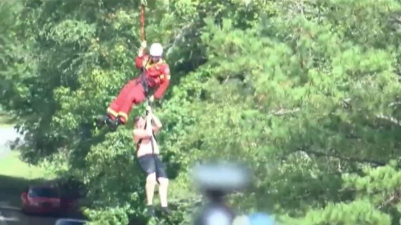 A rescuer pull James Burdette from the Towaliga River after he and his 12-year-old brother Christian were swept off a 20-foot waterfall. Christian Burdette did not survive. (Credit: Channel 2 Action News)
