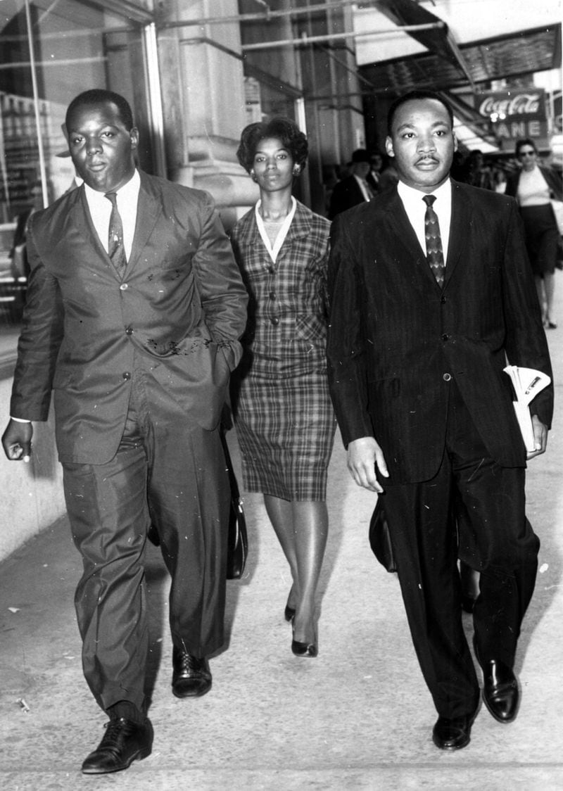 Demonstrators (l-r) Lonnie King, an unknown woman and Martin Luther King Jr. are taken to a police car after being arrested for a sit-in protest at Rich’s departmetn store in Atlanta in 1960. (Charles Jackson/AJC staff) 1960