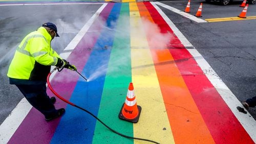 Atlanta Department of Transportation crews cleaned up black tire marks on Midtown’s rainbow crosswalks Tuesday morning after street racers did doughnuts in the intersection over the weekend. (John Spink / John.Spink@ajc.com)