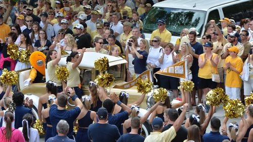 Georgia Tech’s Ramblin’ Wreck leads the band and cheerleaders through hundreds of fans down Yellow Jacket Alley before the start of the Georgia Tech season opener against the Wofford Terriers at Bobby Dodd Stadium on Saturday, August 30, 2014. HYOSUB SHIN / HSHIN@AJC.COM