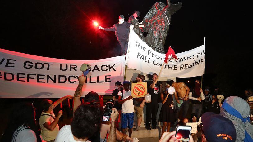 Protesters climbed the Peace Monument in Piedmont Park, spray painted it and tried tearing it down. The structure was erected in 1911 to champion unity and reconciliation. AJC photo: Curtis Compton