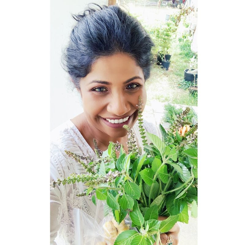 Chef Asha Gomez holds a bouquet of herbs she purchased from Art Farms, a local farm in St. Croix. CONTRIBUTED BY MEREDITH ZIMMERMAN