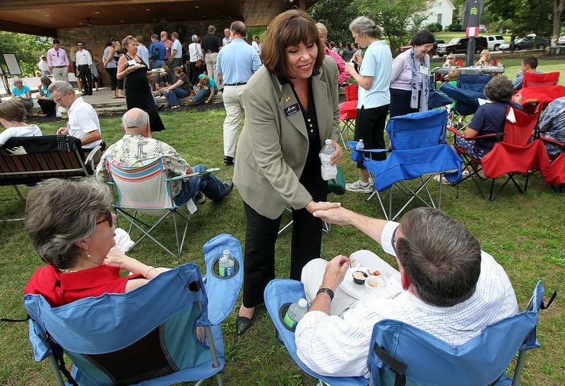 Martha Zoller, candidate for the 9th congressional seat, shakes hands with Terry Dawson with his wife Marie Dawson looking on while working the crowd for votes at the Dahlonega-Lumpkin Chamber After Hours event on Tuesday, Aug. 7, 2012.