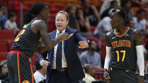 Mike Budenholzer gets all coach-y this preseason with forward Taurean Prince, left, and point guard Dennis Schroder. (AP Photo/Wilfredo Lee)