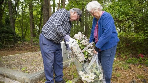 04/18/2019 — Marietta, Georgia — Marvin and Geneva Dunn of Cherokee County clean up their family’s graves at Holly Springs Cemetery, located at 2799 Holly Springs Road, Marietta. The couple heard from a relative about the suspected vandalism at the cemetery and were relieved that Marvin Dunn’s family’s tombstones had not been effected. (ALYSSA POINTER/ALYSSA.POINTER@AJC.COM)