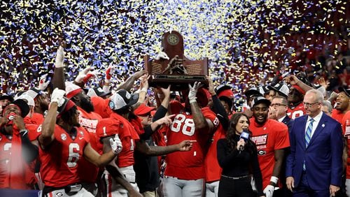 Georgia Bulldogs players hold up the SEC championship trophy after their 50-30 win against the LSU Tigers during the SEC Championship game at Mercedes-Benz Stadium, Saturday, Dec. 3, 2022, in Atlanta. (Jason Getz/Atlanta Journal-Constitution/TNS)