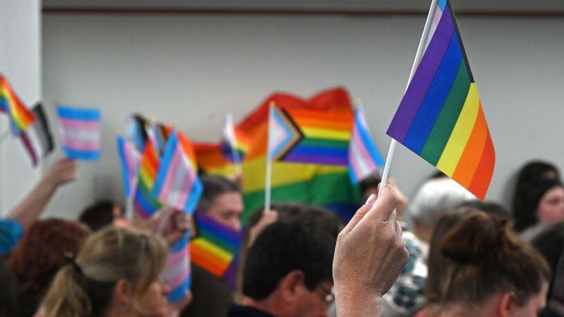 Attendees at a May meeting of the Central Bucks School District wave Pride flags. The district has banned the flags in schools and suspended a teacher who offered support to a transgender student, among other things. (Tom Gralish/The Philadelphia Inquirer/TNS)
