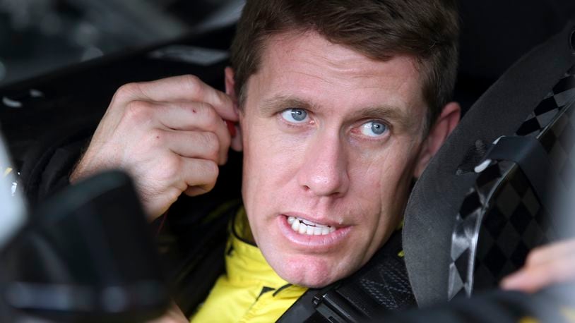 Carl Edwards talks to a crew member before practice for Saturday's NASCAR Sprint Cup series auto race at Charlotte Motor Speedway in Concord, N.C., Friday, Oct. 9, 2015. (AP Photo/Bob Jordan)