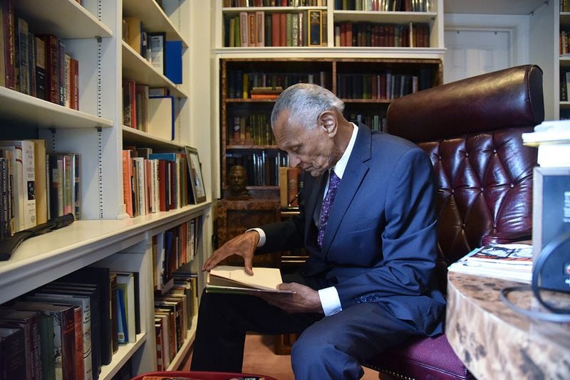 C.T. Vivian looks through a book at his home library on Tuesday, July 25, 2017. The National Monuments Foundation will be acquiring and managing the world-class library of the Civil Rights icon. HYOSUB SHIN / HSHIN@AJC.COM