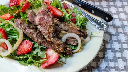 Sweet tart strawberries are paired with grilled skirt steak, Vidalia onions and balsamic vinaigrette for a hearty salad supper.
(Virginia Willis for The Atlanta Journal-Constitution)