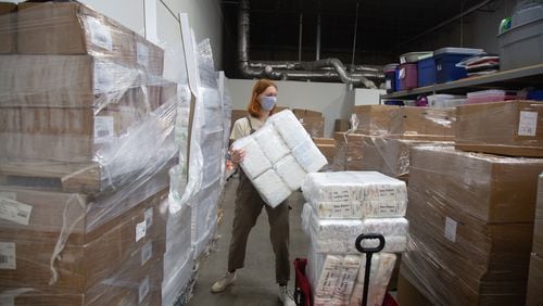 Nonprofit Helping Mamas employee Sydney Leimbach pulls diapers for a request at their Norcross warehouse. Thousands of donated diapers came pouring into the 9,000-square-foot warehouse in Norcross, but unlike past years, there were no volunteers to sort the items. STEVE SCHAEFER FOR THE ATLANTA JOURNAL-CONSTITUTION