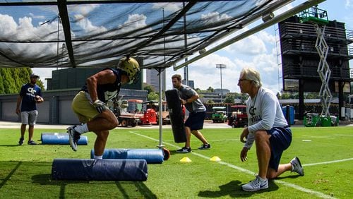 Georgia Tech defensive coordinator Ted Roof watches linebacker T.D. Roof (his son) go through footwork drills at practice.