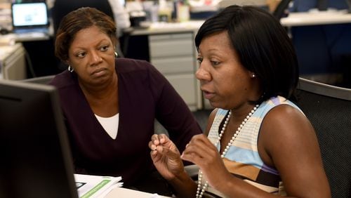 Premium Editor Colleen McMillar, left, listens to AJC reporter Tia Mitchell, as the two go over a story. RYON HORNE/RHORNE@AJC.COM