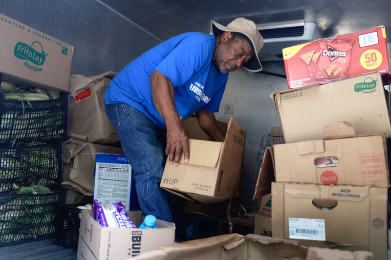 The Metro Atlanta Urban Farm founder Bobby Wilson takes food out of his truck for a free food bank in the West End neighborhood in Atlanta on Tuesday, July 25, 2023. (Natrice Miller/natrice.miller@ajc.com)