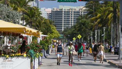 Pedestrians make their way down Ocean Drive in Miami Beach, Florida. To help address climate change, city leaders will cut back on the number of new palm trees in the city and add more shade trees to the Beach's canopy. (Matias J. Ocner/Miami Herald/TNS)